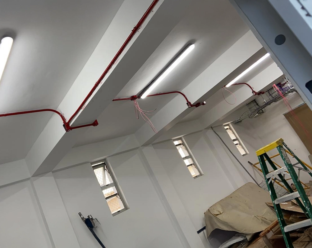 Tubería roja de rociadores instalada bajo el techo de la nave, con sus ramales y los rociadores ya montados
